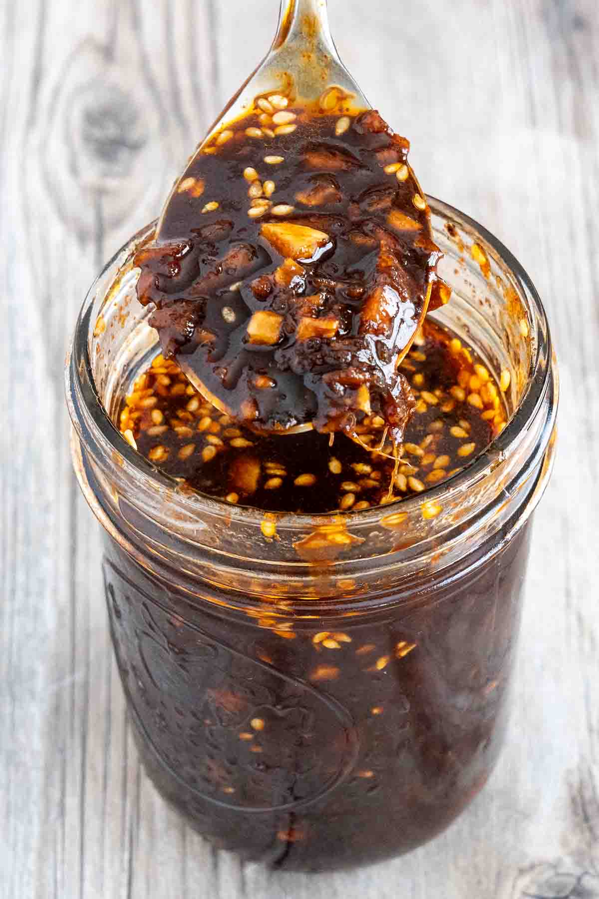 Bulgogi sauce in a glass jar with a spoon coming out.