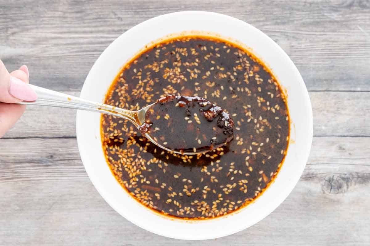 Bulgogi sauce in a white bowl with a spoon holding sauce.