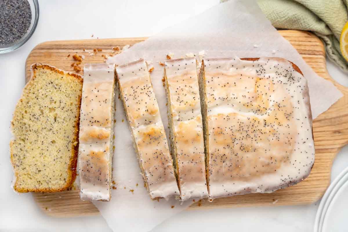 Sliced lemon poppy seed cake on a cutting board.