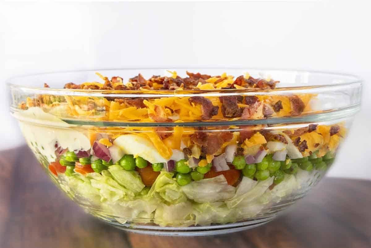 Seven layer salad in a glass bowl.
