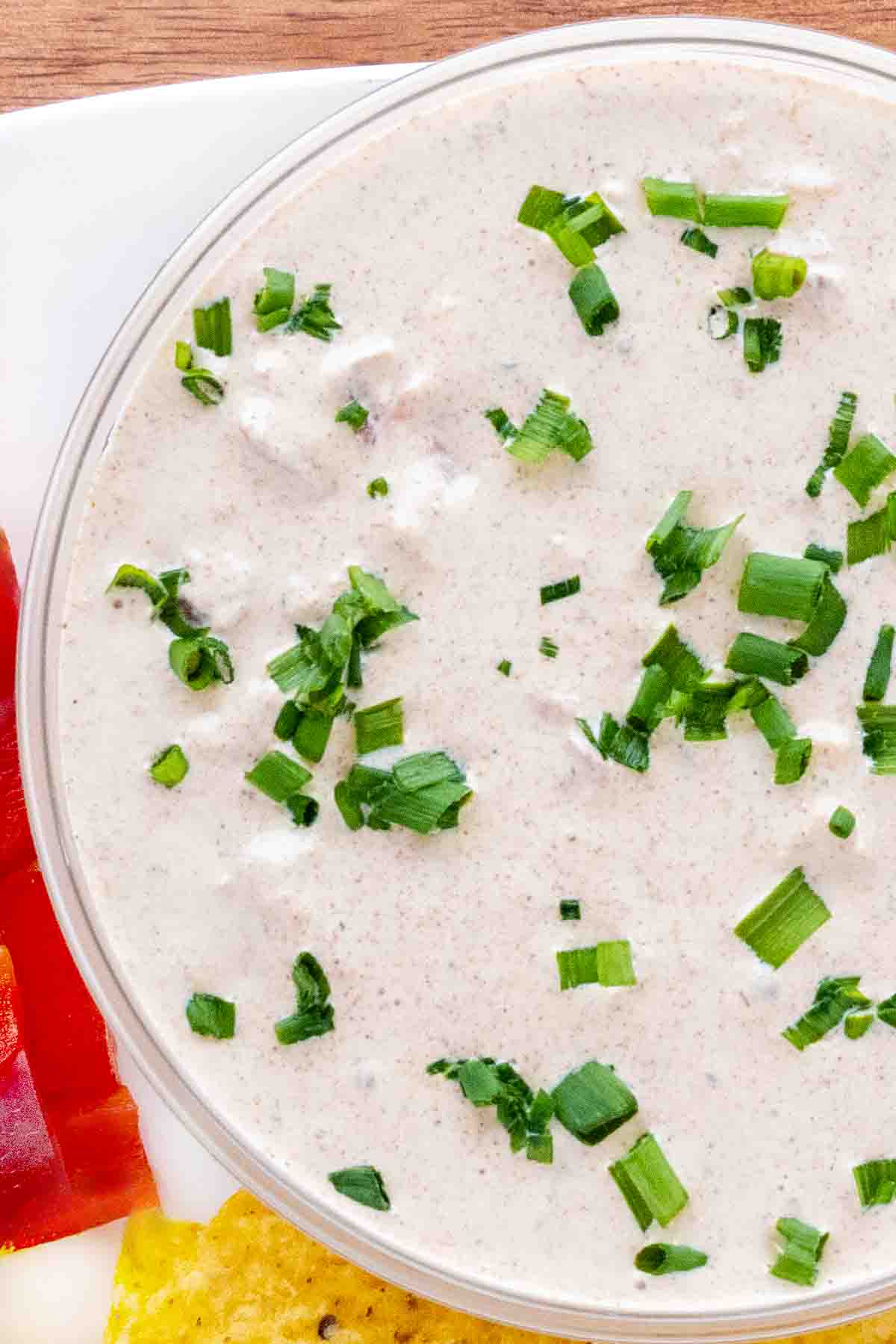 Boat dip with chopped chives in a glass bowl.