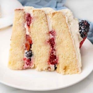 Slice of Chantilly cake on a white plate.