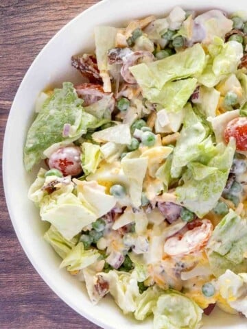 Seven layer salad in a white bowl.