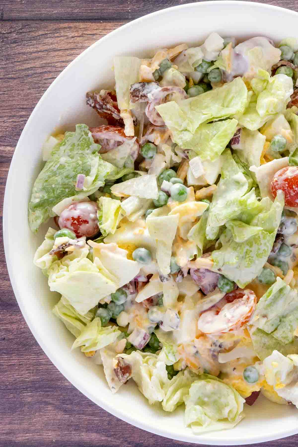 Seven layer salad in a white bowl.