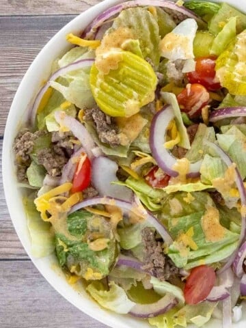 Big mac salad in a white bowl.