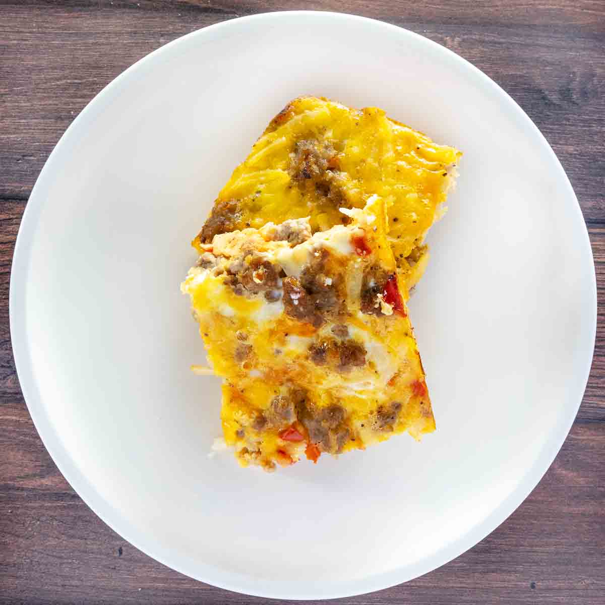Two slices of breakfast casserole on a white plate.