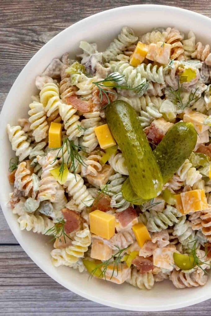 Dill pickles pasta salad in a white bowl.