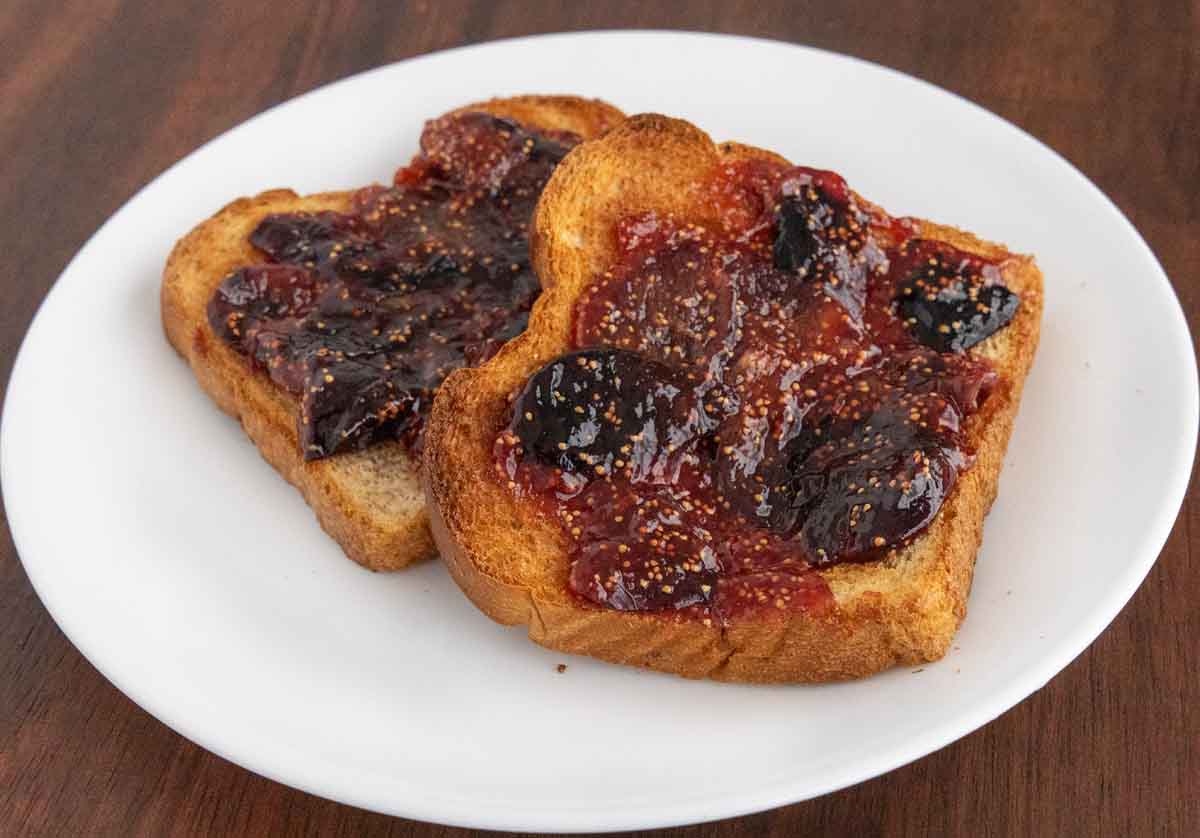 Fig jam on toast on a white plate.