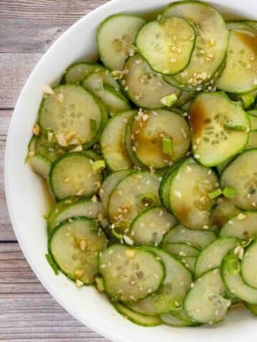 Asian cucumber salad in a white bowl.
