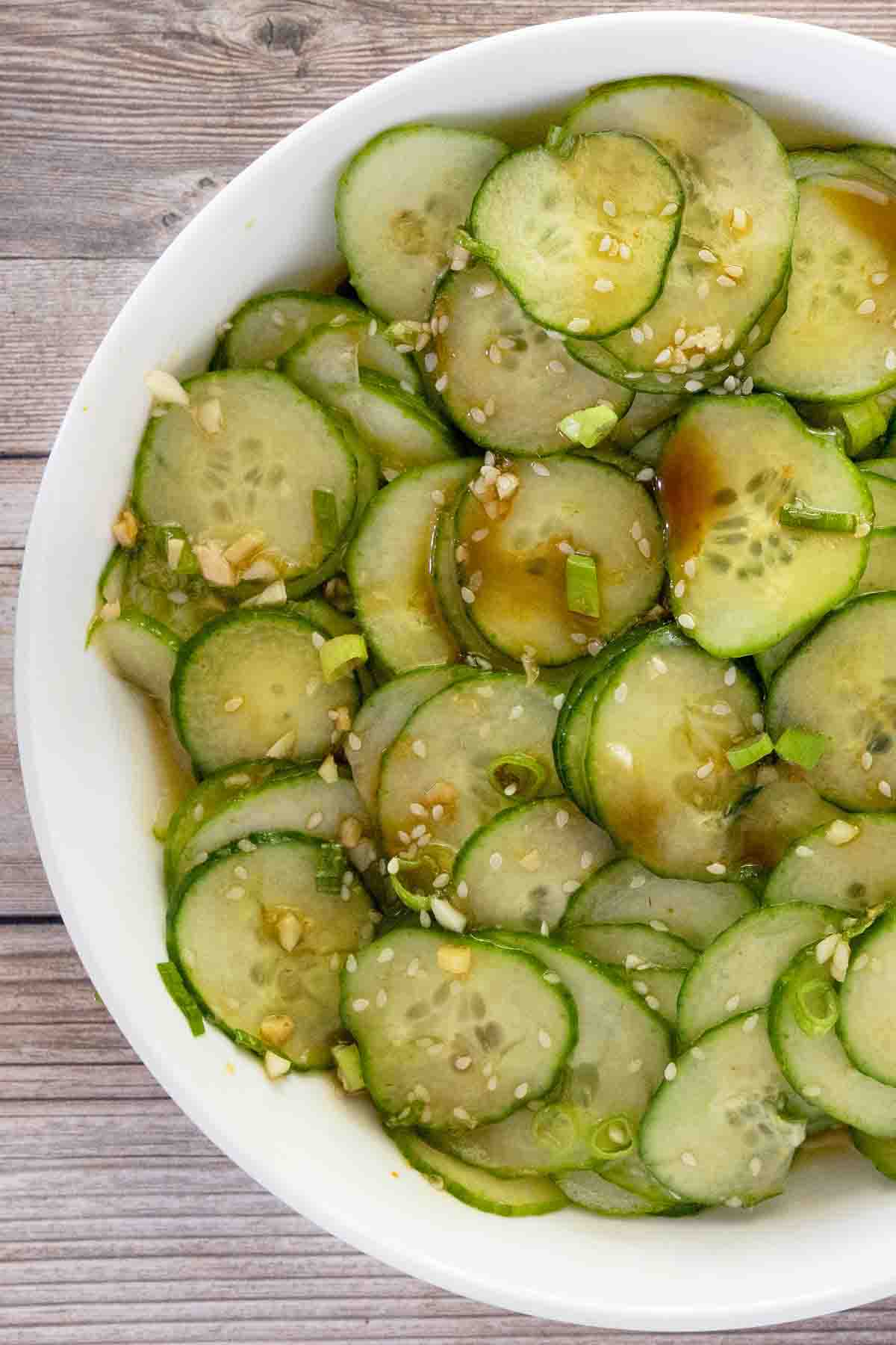Asian cucumber salad in a white bowl.