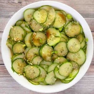Asian cucumber salad in a white bowl.