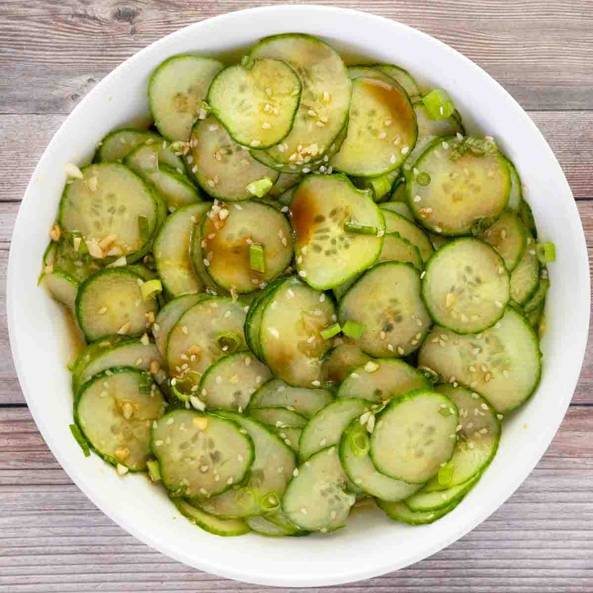 Asian cucumber salad in a white bowl.