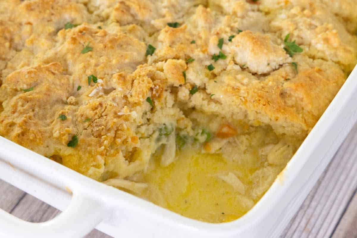 Chicken cobbler in a baking dish with a piece taken out.