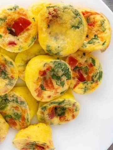 Egg bites stacked on a white platter.