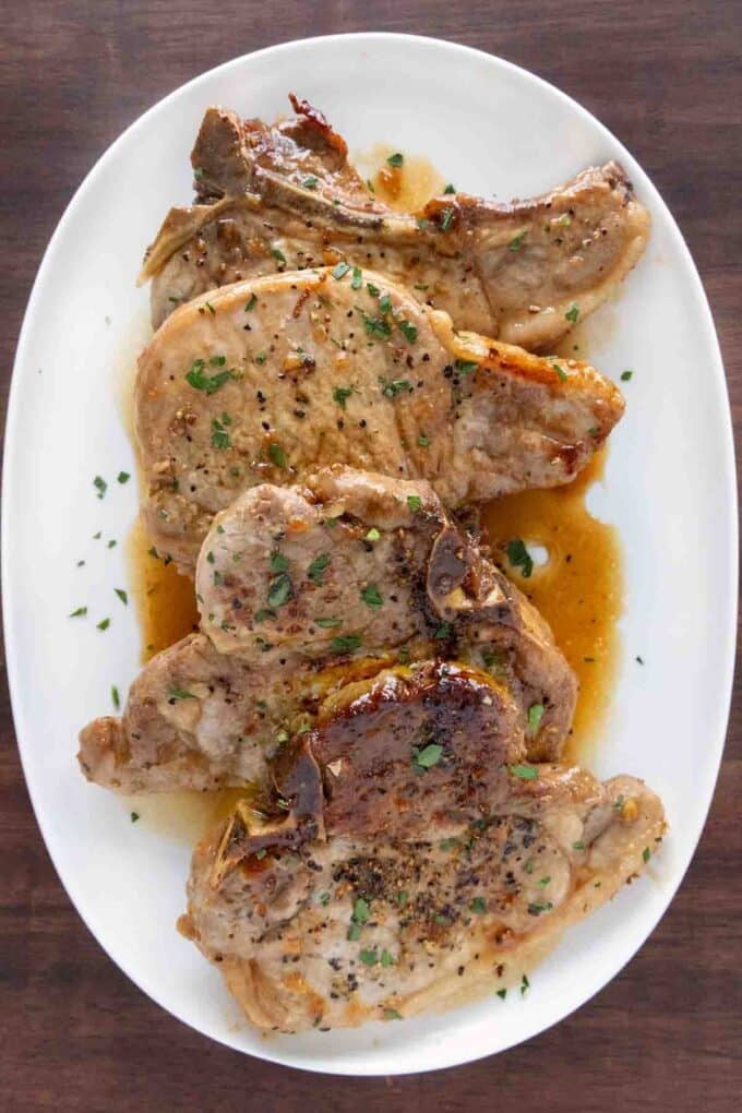 Honey garlic pork chops on a white platter.