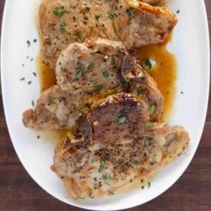 Honey garlic pork chops on a white platter.