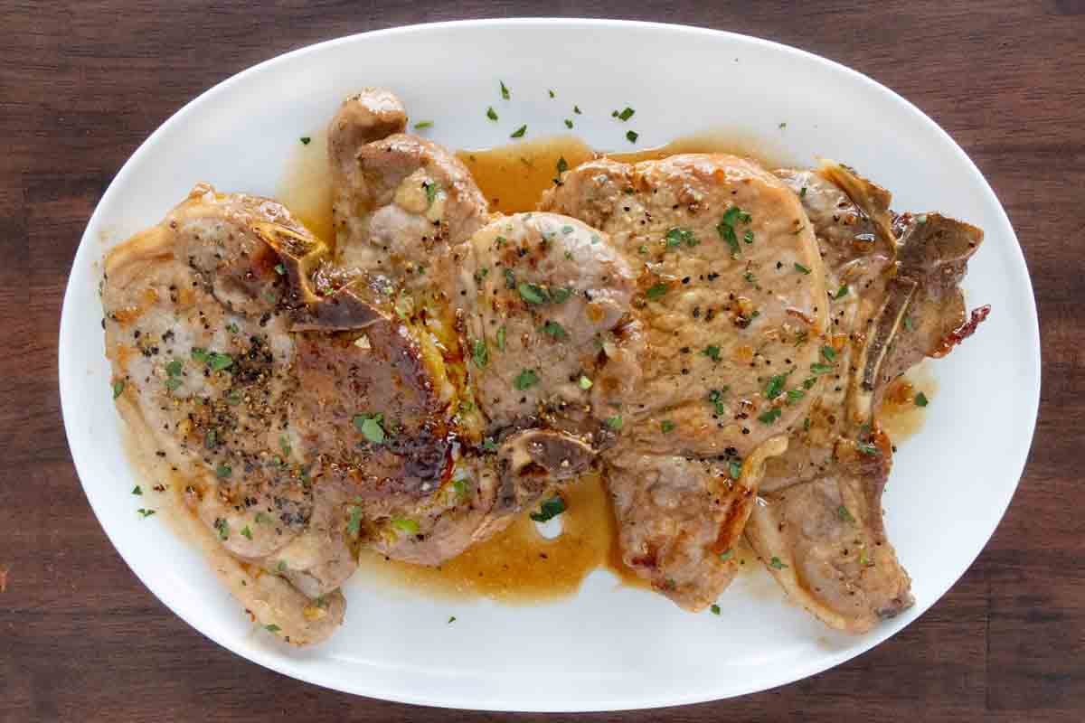 Honey garlic pork chops on a white platter.