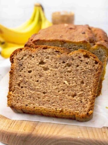 Loaf of peanut butter banana bread sliced on cutting board.