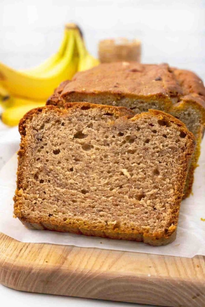 Loaf of peanut butter banana bread sliced on cutting board.