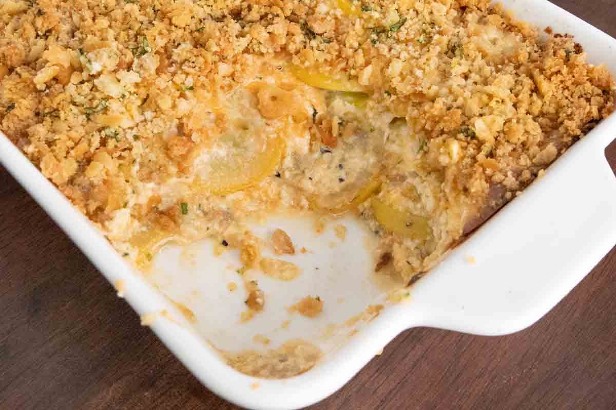Squash casserole in a white baking dish.