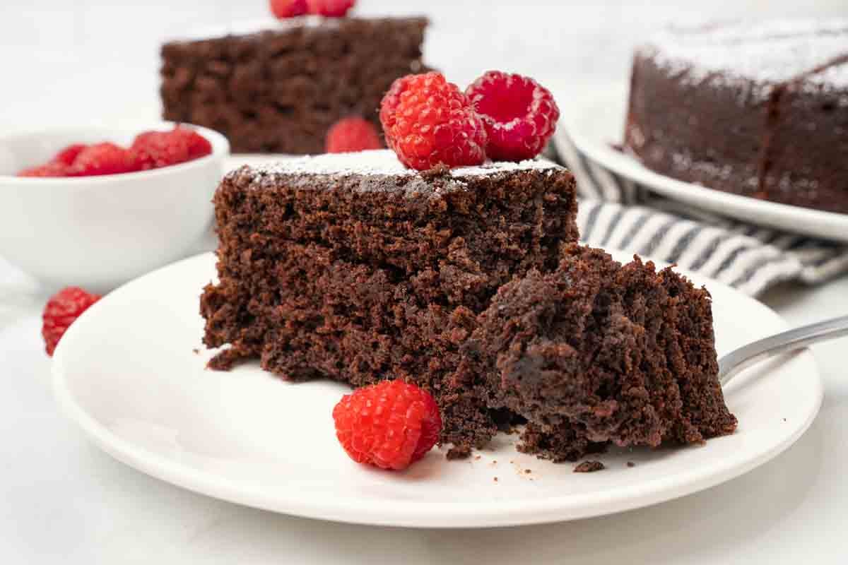 Cocoa cake on a white plate with a fork taking a piece out.