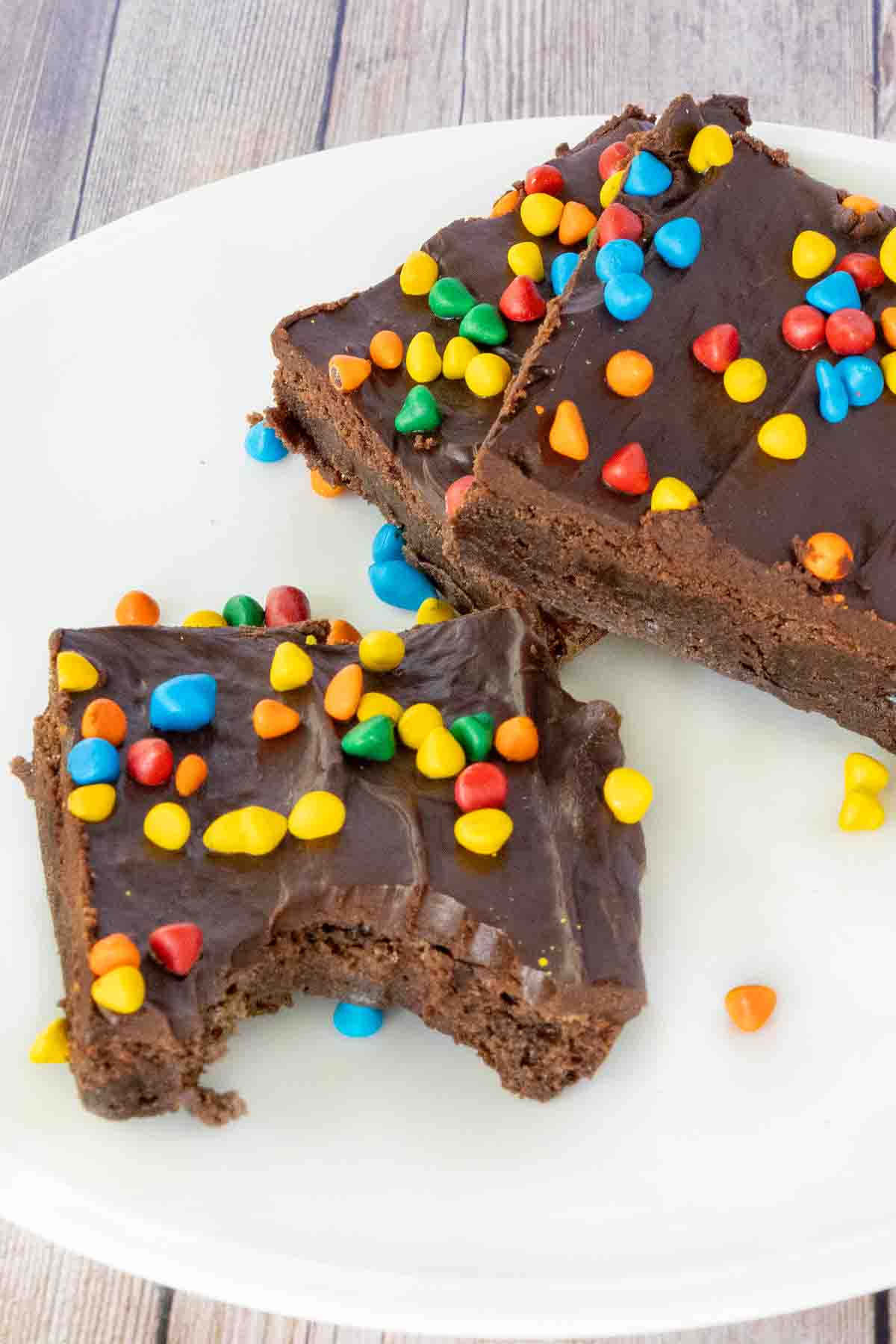 Cosmic brownies on a white plate, one with bite taken out.