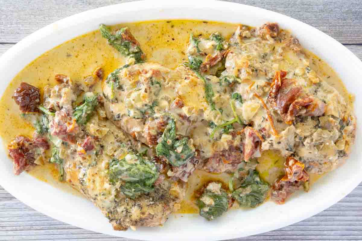 Crockpot tuscan chicken on a white platter.