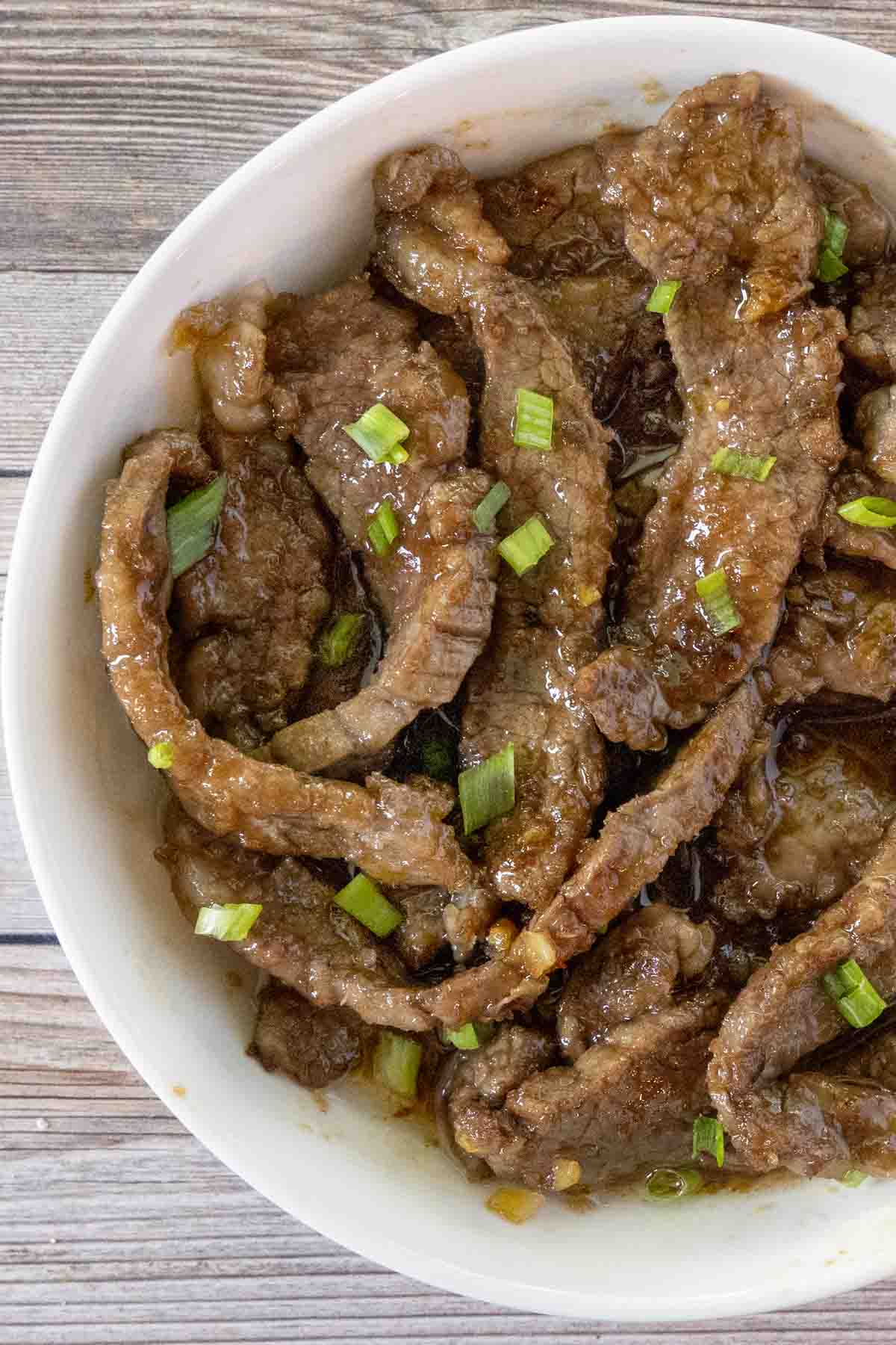 Mongolian beef in a white bowl.