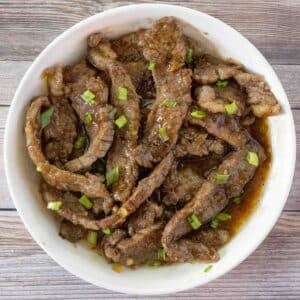 Mongolian beef in a white bowl.
