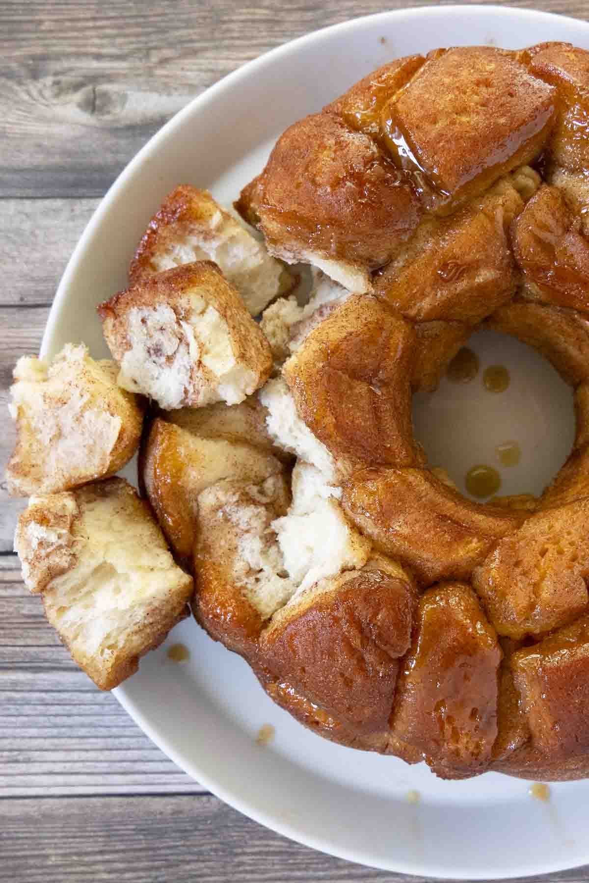 Monkey bread on a a white platter with a few pieces pulled out.