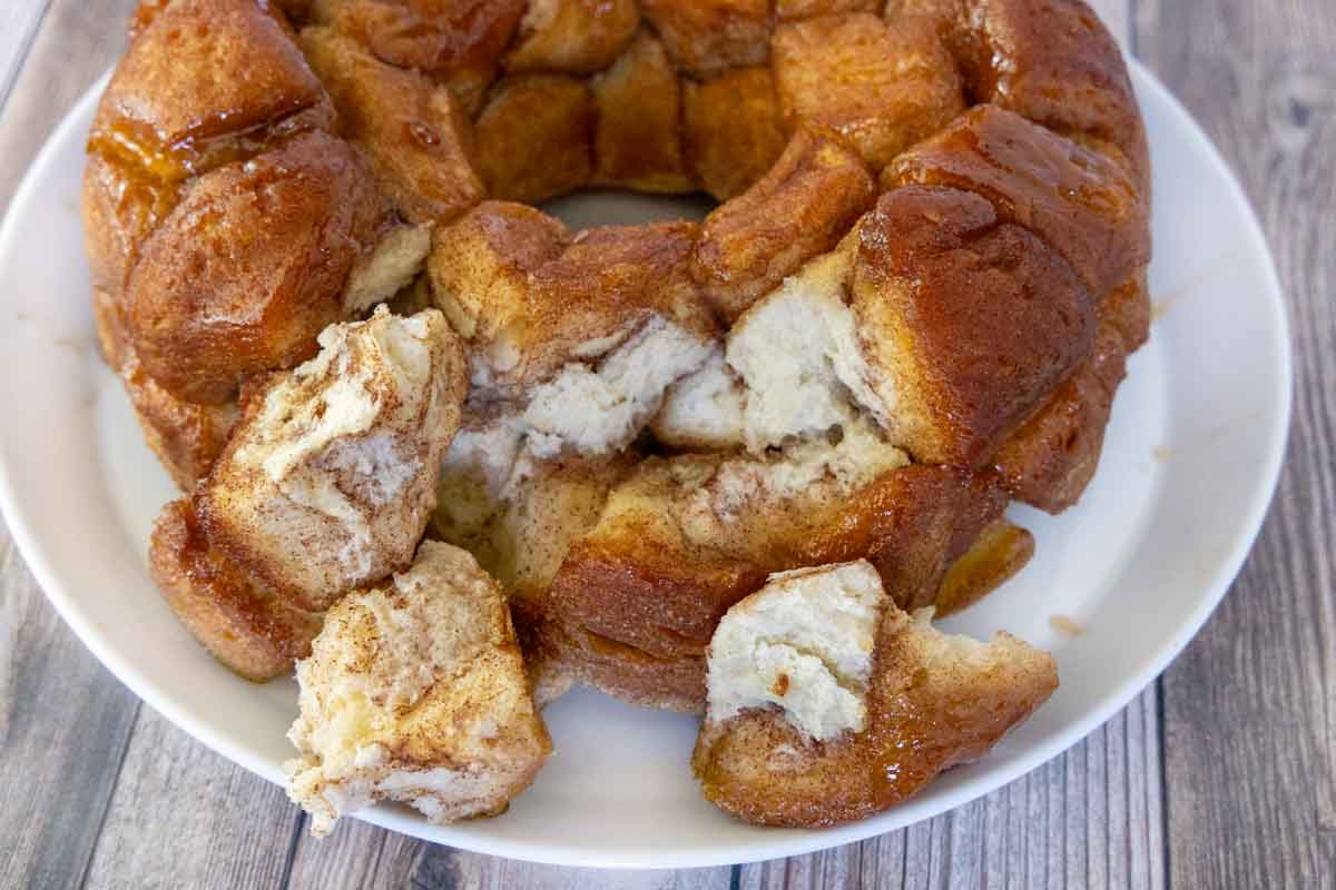 Monkey bread on a a white platter with a few pieces pulled out.
