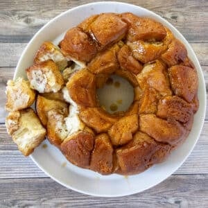 Monkey bread on a a white platter with a few pieces pulled out.