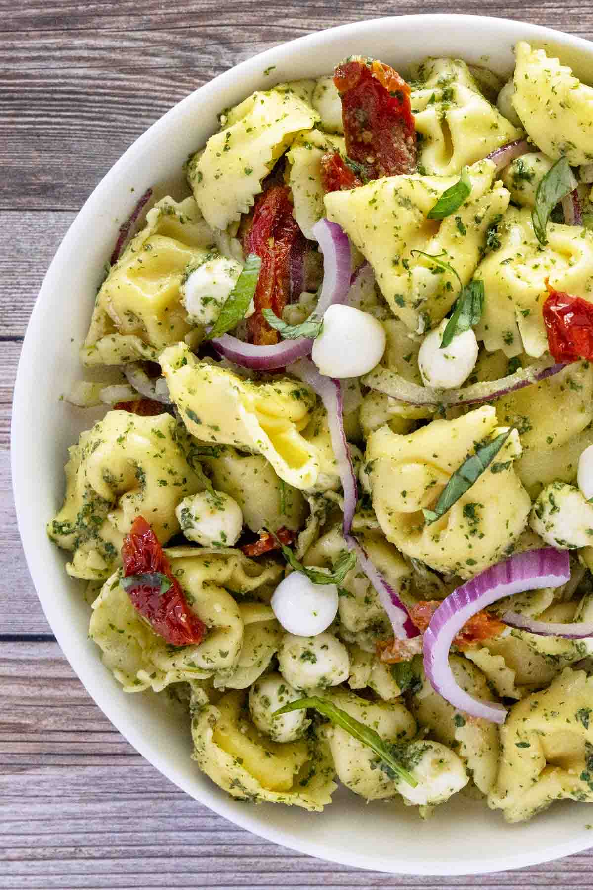 Pesto pasta salad in a white bowl.