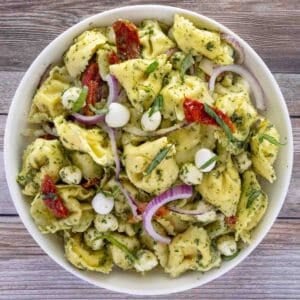 Pesto pasta salad in a white bowl.
