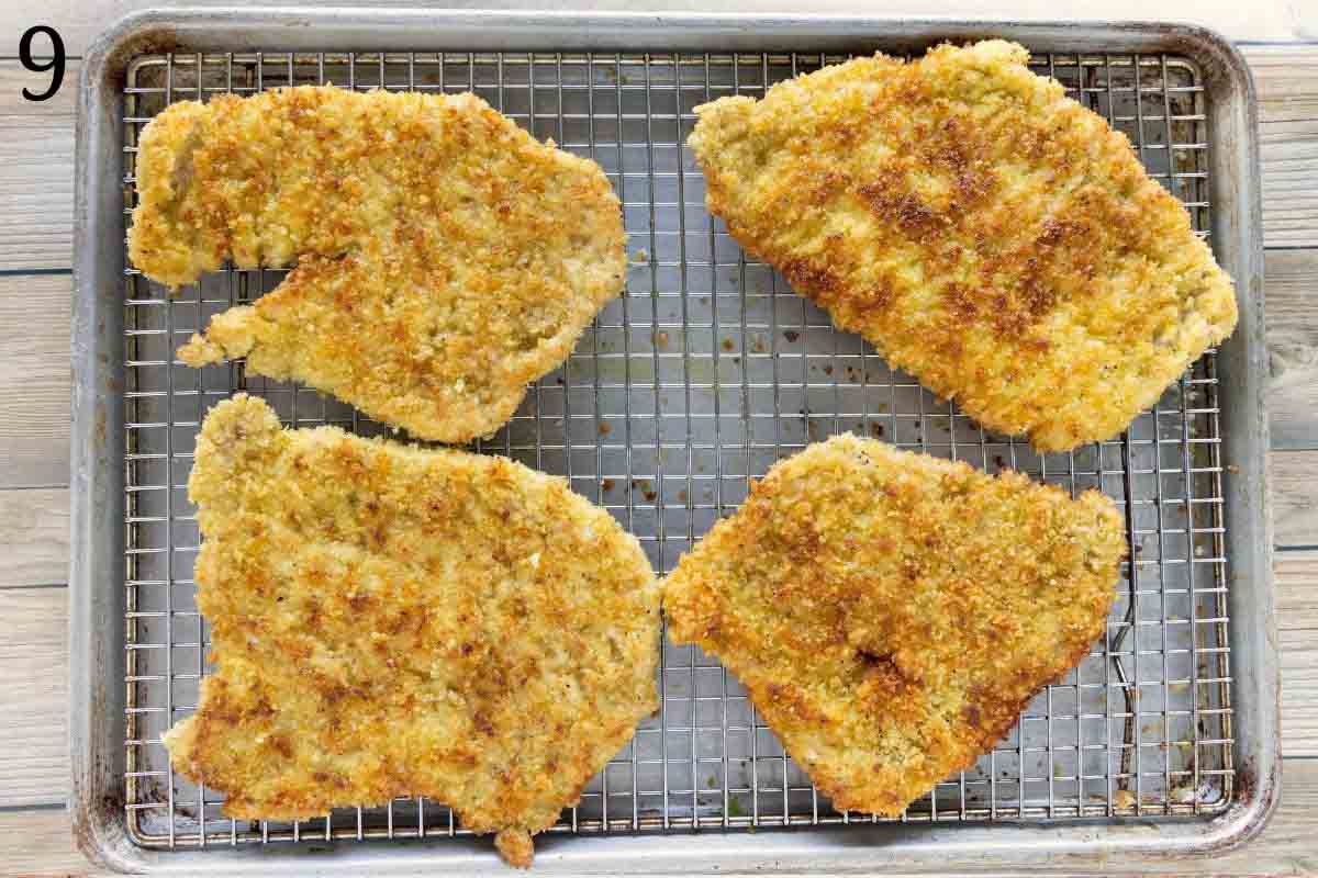 Cutlets draining on a wire rack over a sheet pan.