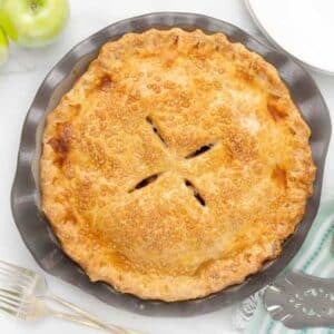 Top view of baked apple pie in a brown pie plate.