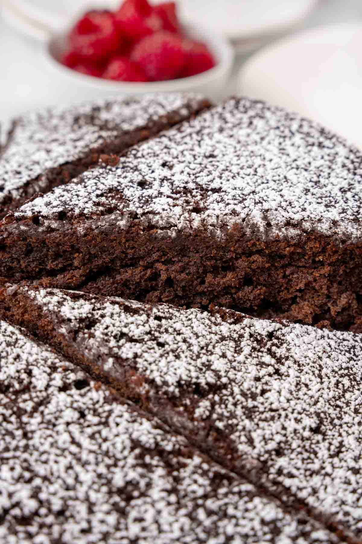 Slice of cocoa cake being take out of the whole cake.