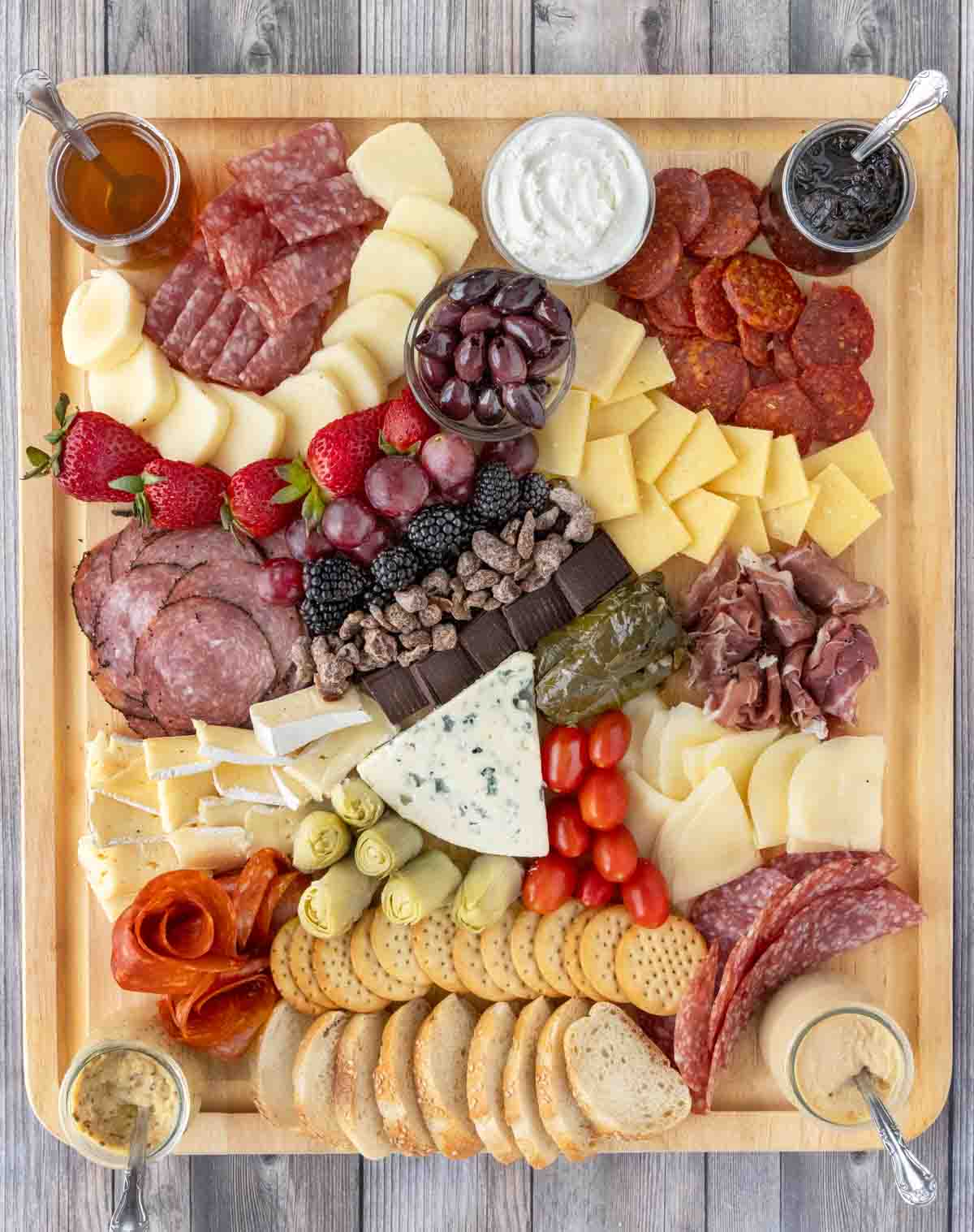 Charcuterie set out on wooden cutting board.