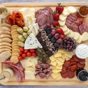 Charcuterie set out on wooden cutting board.