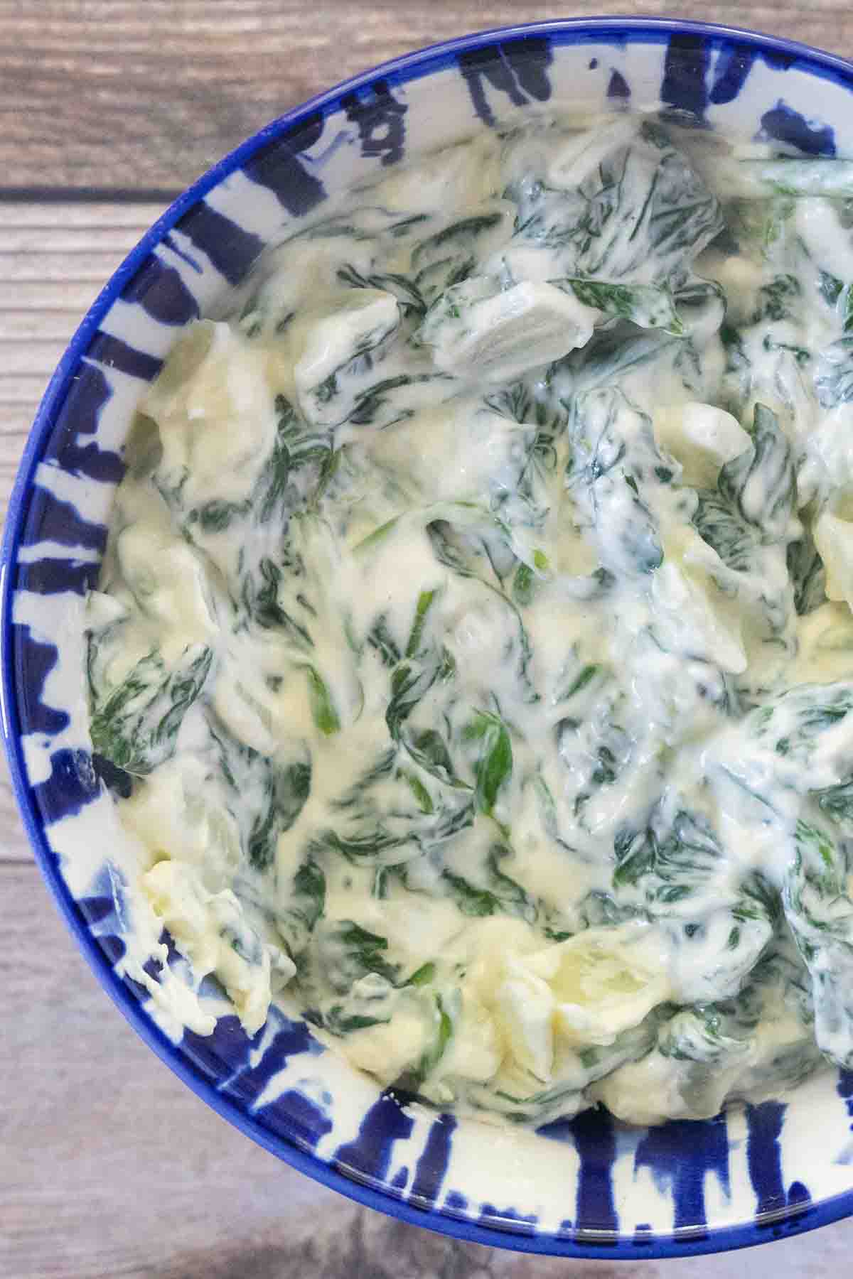 Creamed spinach in a blue and white bowl.