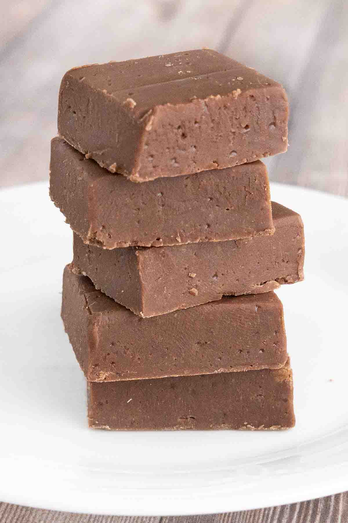 Stack of chocolate fudge on a white plate.
