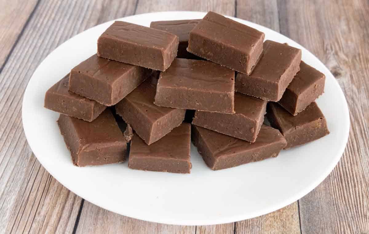 Chocolate fudge stacked on a white platter.