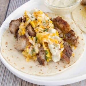 Pork belly taco on a white platter.