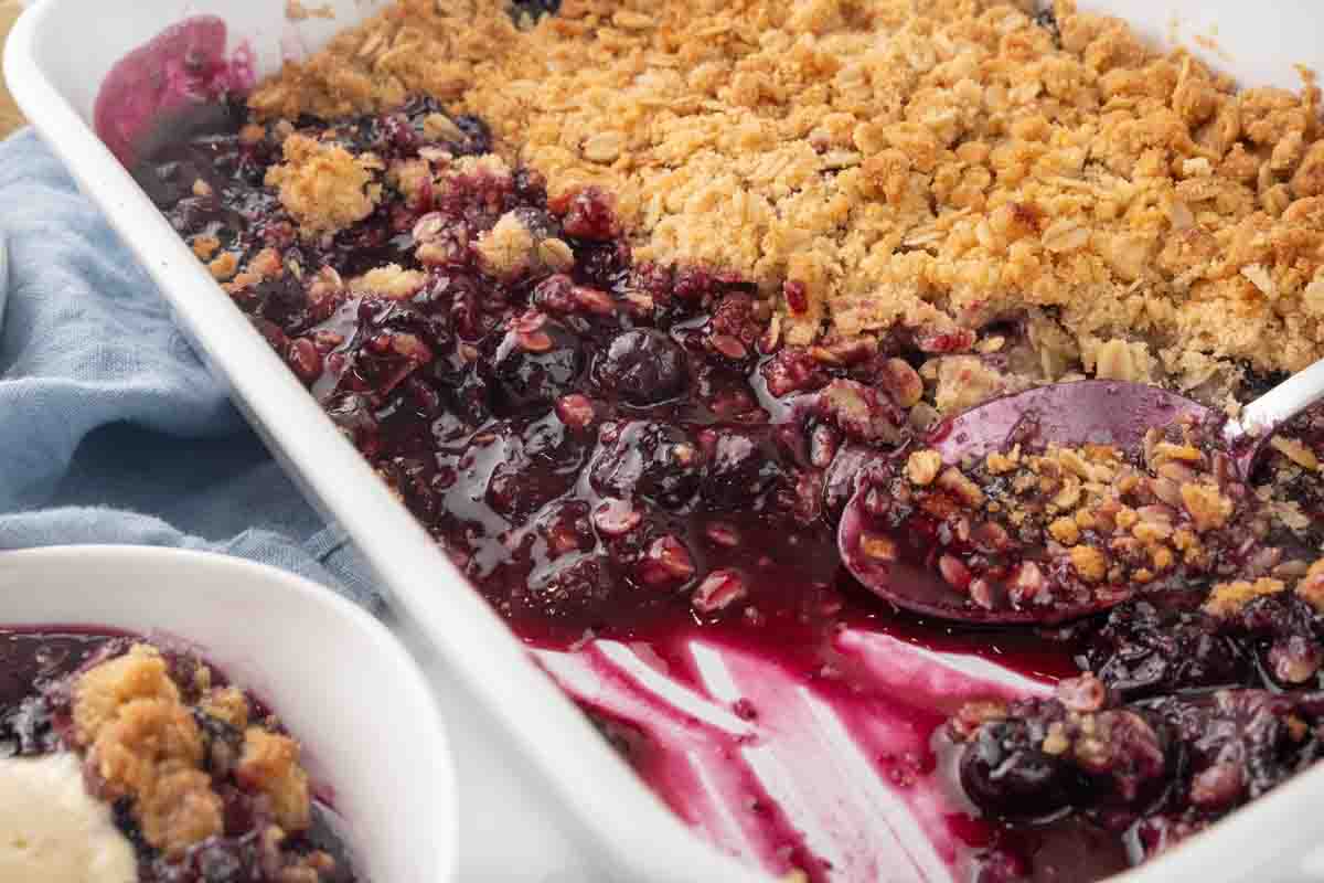 Pan of blueberry crumble with some scooped out.