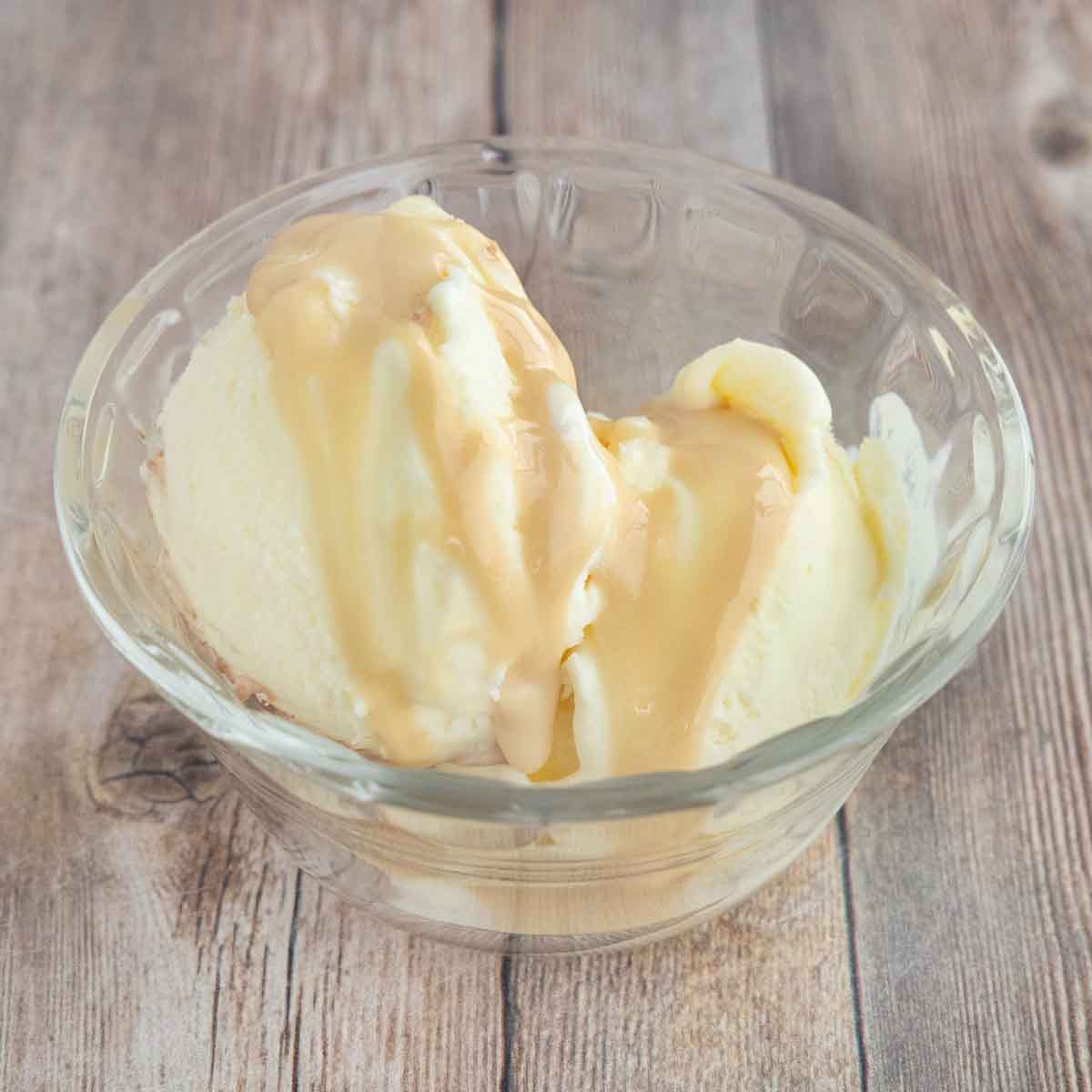 vanilla ice cream with topped with whipped honey in a glass bowl.