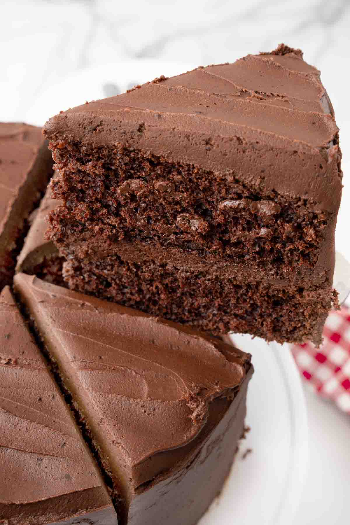 Slice of Matilda's chocolate cake being taken out of the whole cake.