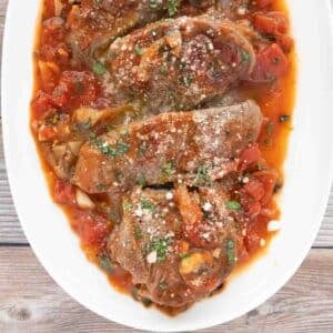 Steak Pizzaiola on a white platter.