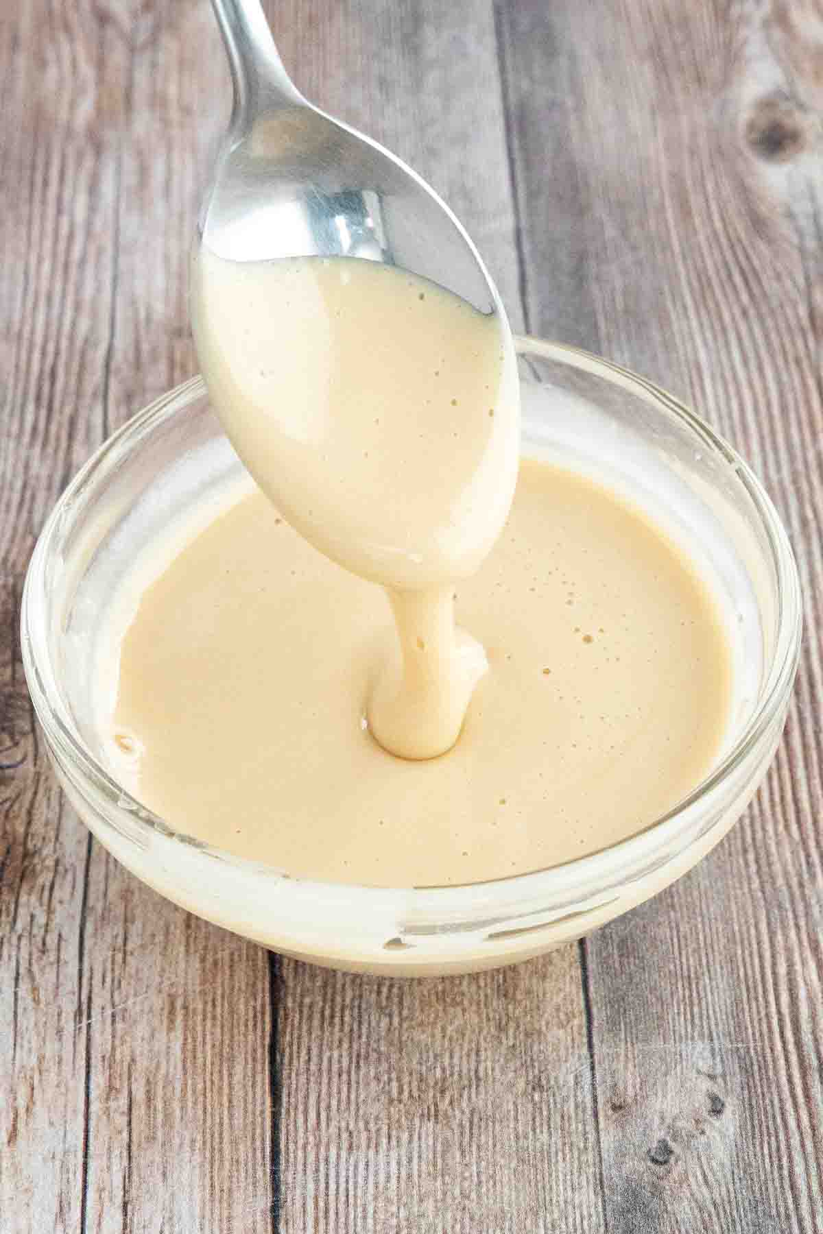 Whipped honey in a bowl with a spoon coming out.