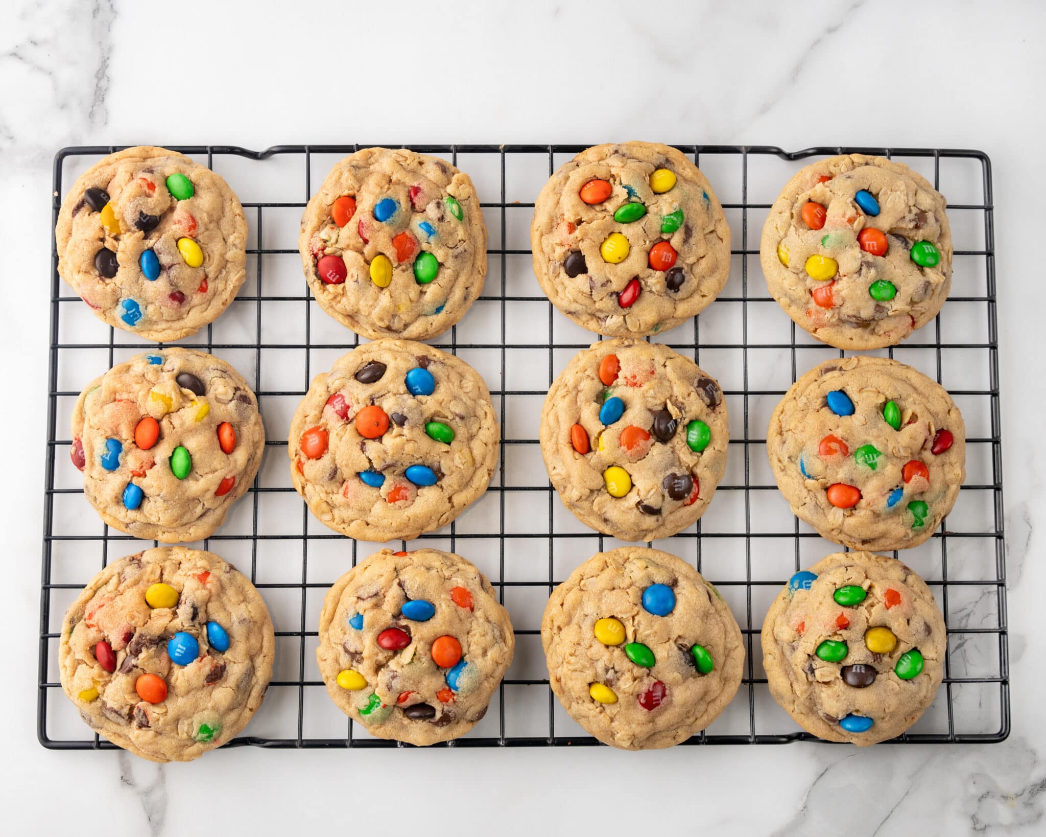 Monster cookies on a cooling rack.