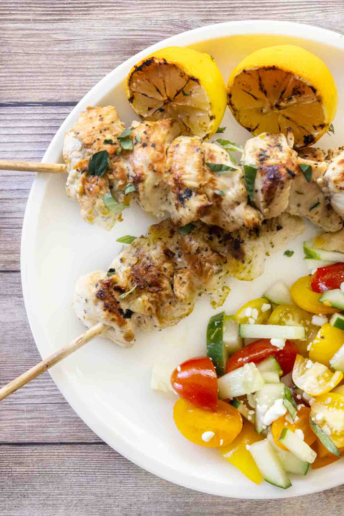 Chicken souvlaki on a white plate.